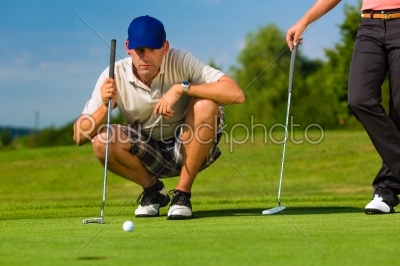 Young sportive couple playing golf on a course