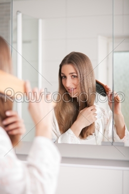 Young woman brushing her hair 