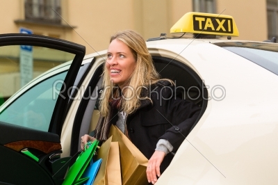Young woman gets out of taxi