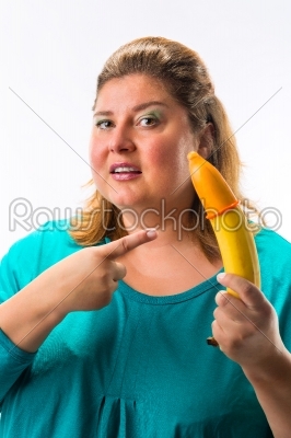 Young woman holding  banana with condom 