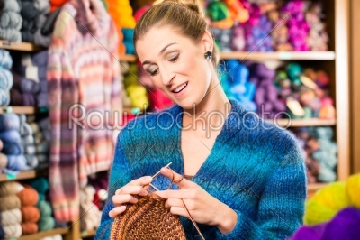 Young woman in knitting shop with circular needle