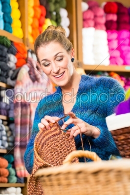 Young woman in knitting shop with circular needle