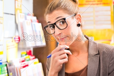 Young woman in Lotto shop playing ticket