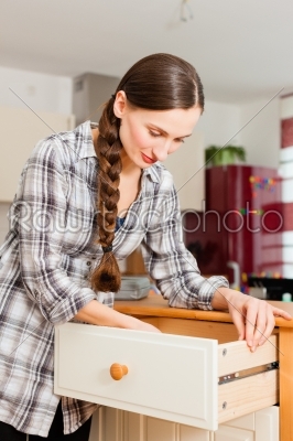 Young woman is assembling a cupboard