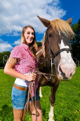 Young woman on the meadow with horse