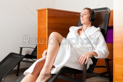 Young woman relaxing in spa with music