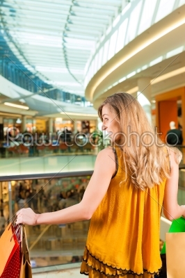 Young woman shopping in mall with bags