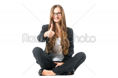 Young woman showing success sitting cross legged