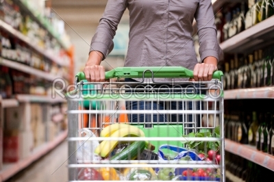 Young woman with pushcart in supermarket
