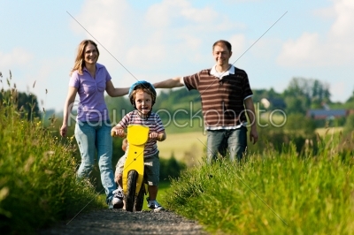 Active family in summer walking and bicycling