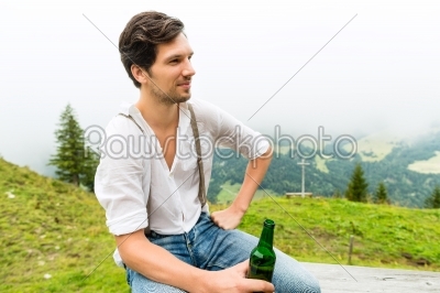 Alps - Man in mountains drinking beer from bottle