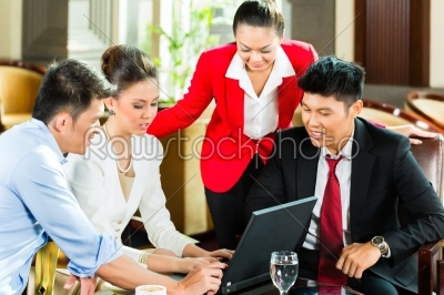 Asian business people at meeting in hotel lobby