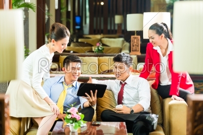 Asian Chinese business people meeting in hotel lobby