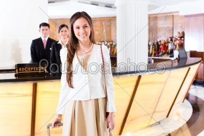 Asian Chinese woman arriving at hotel front desk