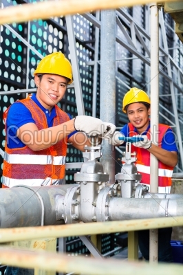 Asian Technicians or engineers working on valve 