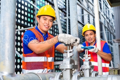 Asian Technicians or engineers working on valve 