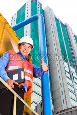 Asian worker or supervisor on building site  