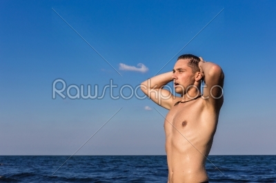 Attractive young man in the sea getting out of water