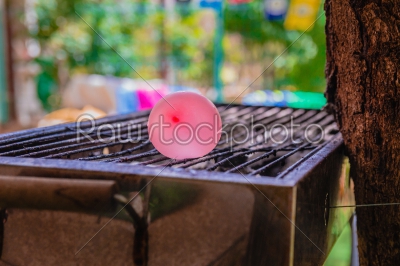 Balloon filled with water placed on a hot grill