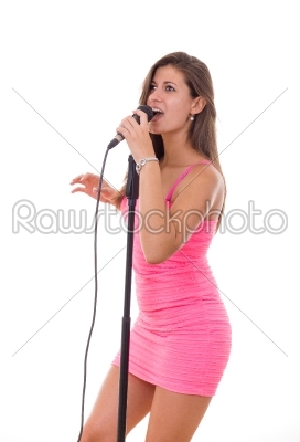 beautiful girl holding microphone and singing in a dress