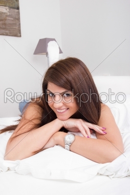 beautiful young woman lying on the bed smiling