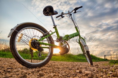 Bicycles parked on a dirt road during sunset