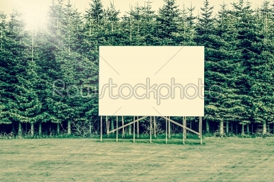 Big billboard sign surrounded by trees