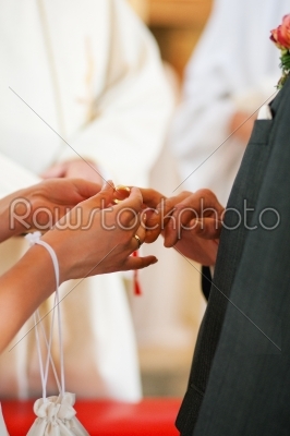 Bride giving ring to groom in wedding