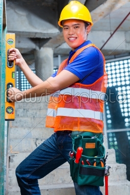 Builder or worker controlling wall on construction site