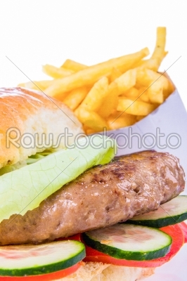 burger in bun with french fries and salad