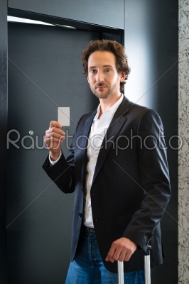 Businessman with key card for room door in hotel