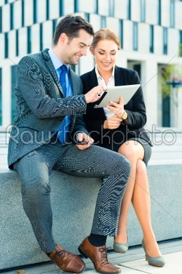 Businesspeople working outdoor with tablet computer