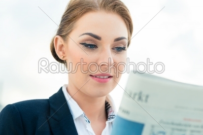 businesswoman reading business newspaper