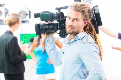 Cameraman shooting with camera on film set