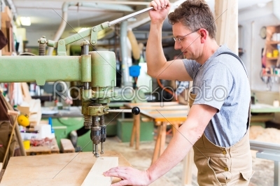 Carpenter using electric drill in carpentry