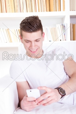 casual happy young man sending message on mobile phone