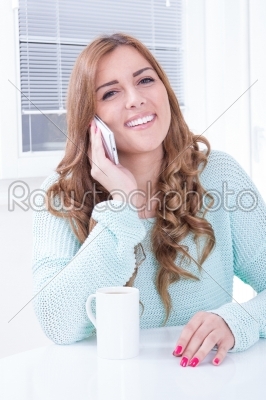 caucasian lady with cellular phone and drinking coffee