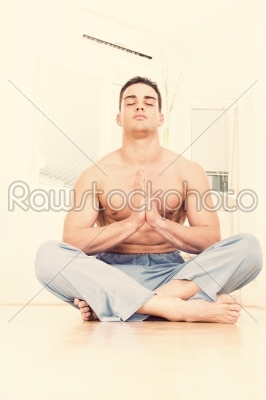 Caucasian male man doing yoga prayer pose indoors