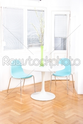 central table with flower in front of windows in dining room