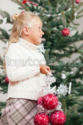 Child decorating the Christmas tree