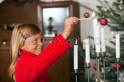 Child lighting Christmas candles