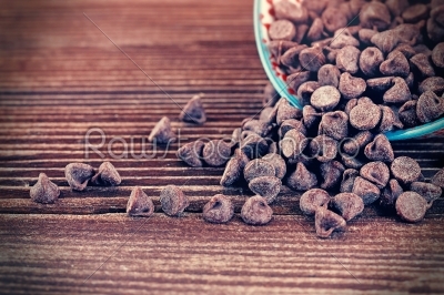Chocolate chips overflowing onto wood table