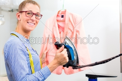 Cleaner in laundry shop ironing jacket 