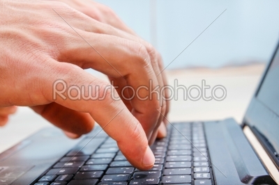 closeup hands on laptop keyboard typing