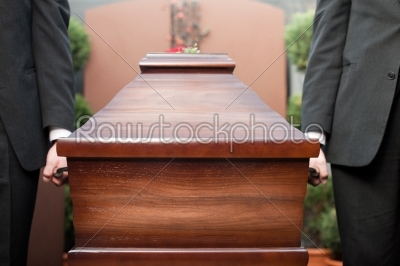 coffin bearer carrying casket at funeral