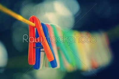 Colorful clothes pegs hanging in wire