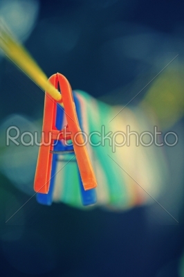 Colorful clothes pegs hanging in wire