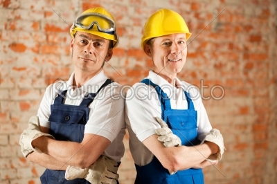 Construction workers standing with folded arms