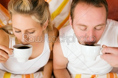 Couple drinking some coffee in the bead in morning
