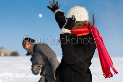 Couple having a snowball fight in winter